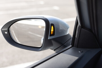 System blind spots of the car. Detail of side keeping assist system switch button. Blind zone monitoring sensor on the side mirror of a modern electric car