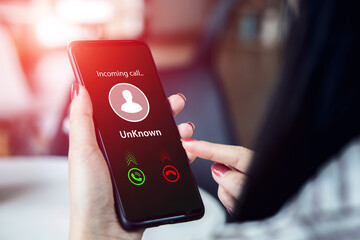 A woman receives a phone call from an unknown number. concept of scammers or strangers, fraud, and...