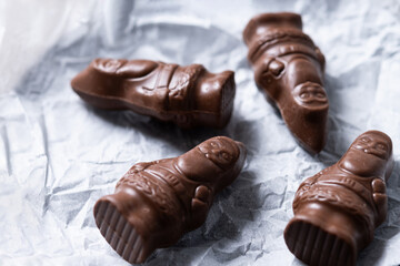 cheerful wrapped chocolate Santa Claus on wooden table