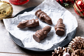 cheerful wrapped chocolate Santa Claus on wooden table