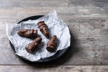 cheerful wrapped chocolate Santa Claus on wooden table