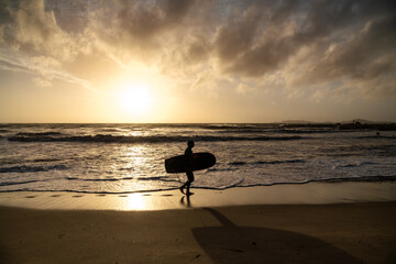 Fototapeta na wymiar silhouette of a surfer on the beach