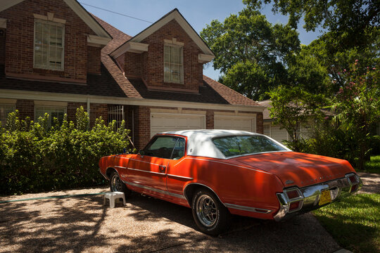 White and red vintage Oldsmobile parked at the entrance of an exclusive detached house in Afton Oaks, Houston