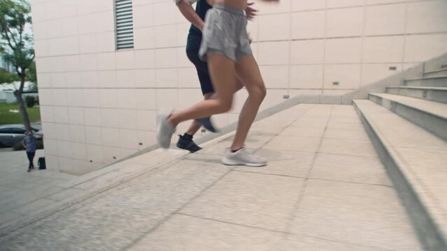 Cropped shot of man and woman jogging upstairs while training in morning outdoors