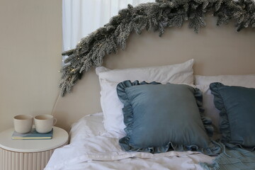 bedroom decorated for the new year with blue pillow and Christmas tree garland