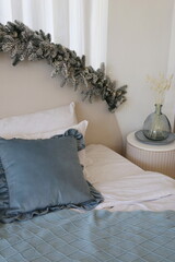 bedroom decorated for the new year with blue pillow and Christmas tree garland