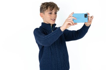 Caucasian teen boy taking a selfie to post it on social media or having a video call with friends.
