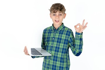 Positive  Caucasian teen boy wearing plaid shirt hold wireless netbook hand fingers show okey symbol