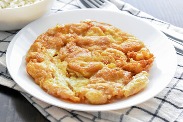 Thai omelette on a white plate.