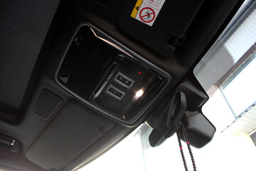 Black ceiling in a luxury SUV. Rear view mirror of a car. Rearview mirror with rain sensor and light. Sun visor auto. Car interior. Car driver ceiling.