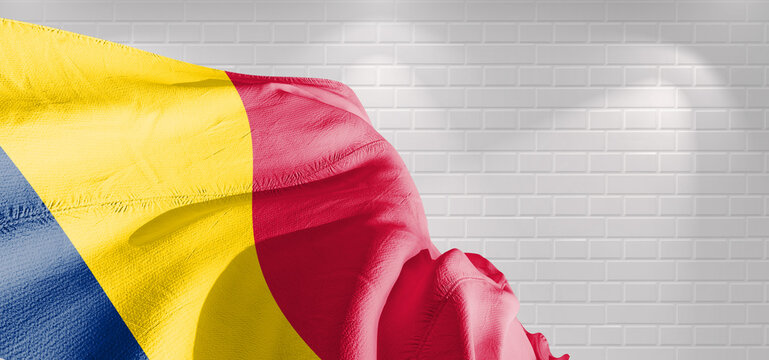 Chad national flag cloth fabric waving on beautiful bricks Background.