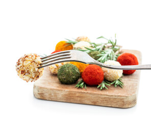 Cheese balls covered with various spices and nuts decorated with rosemary sticks isolated on white