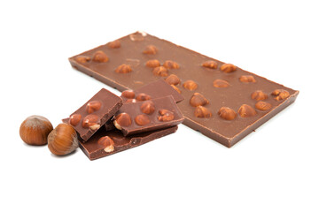 Whole milk chocolate bar and chocolate pieces with hazelnuts isolated on white background.