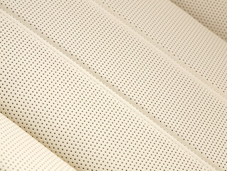Part of leather car headrest seat details. Сlose-up white   perforated leather car seat. Skin texture
