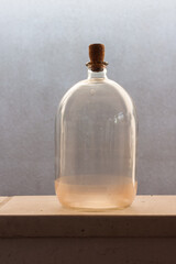 Old glass bottles is illuminated by yellow evening sun light. Close-up
