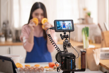 Food blogger streaming live, pretty woman vlogger and online influencer is recording a video about healthy food in the kitchen, selective focus