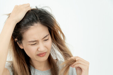 Asian woman very sad and upset looking at damaged hair, hair loss, hair thinning problem, vitamin deficiency, baldness, postpartum, biotin, zinc, menstrual or endocrine disorders, hormonal imbalance