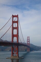 Vertical shot of the beautiful Golden Gate Bridge over the water on a bright day