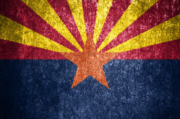 Close-up of the grunge Arizona state flag. Dirty Arizona state flag on a metal surface.