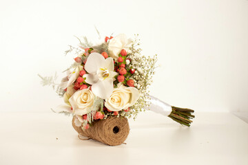 Ramo de novia con rosas blancas y flores de orquídeas en un jarrón aislado sobre fondo blanco.