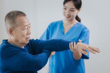 Fototapeta premium Asian female doctor or nurse exercising with elderly man at hospital