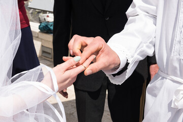 Groom places the ring on the bride's finger