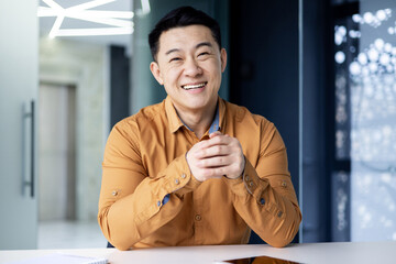 Joyful successful businessman watching in web camera, smiling man talking with colleagues remotely...