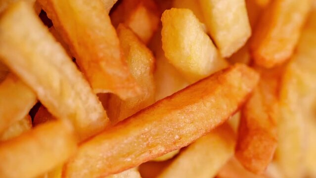 French fries potato, in bulk, rotating, turning, close-up macro, top view, selective focus

