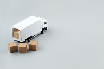 White toy truck with boxes on a light background, space for text.