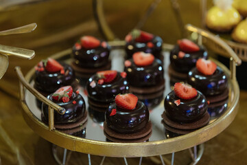 Candy bar, dessert sweet table, cakes are on round tray at wedding event, party, holiday. Enjoying. 