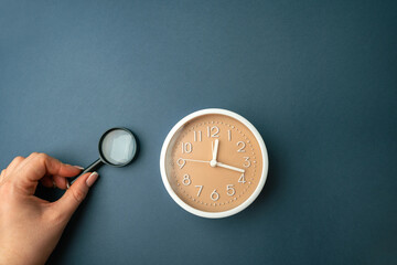 Magnifying glass and clock. Business planning concept. Waiting for a meeting, a date. The cost of...