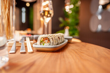 Sushi roll with cream cheese, sesame seeds and green flying fish caviar