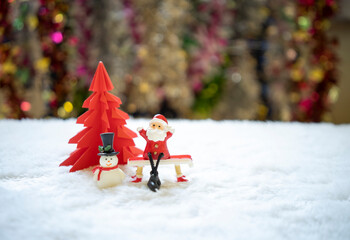 Sata sitting on red bench with snowman  in front of red origami Christmas tree waiting for funny...