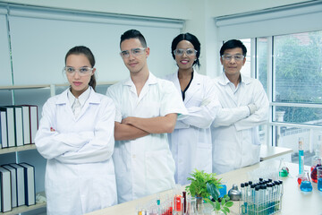 Portrait group multi-ethnic scientists standing smiling happily and cross one's arm in...