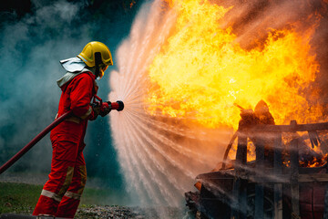 Burning car, Fireman water spray by high pressure nozzle in fire fighting operation, Fire and...