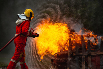 Burning car, Fireman water spray by high pressure nozzle in fire fighting operation, Fire and...