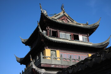 Naklejka premium chinese temple building a golden Buddhist temple stands vibrant against a clear blue sky in Zhujiajiao, China.