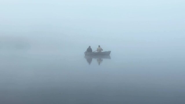 Two fishermen fishing in the fog