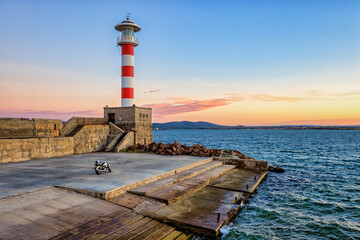 The bike and the Lighthouse on the pier at sunset 