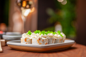 Sushi roll with cream cheese, sesame seeds and green flying fish caviar
