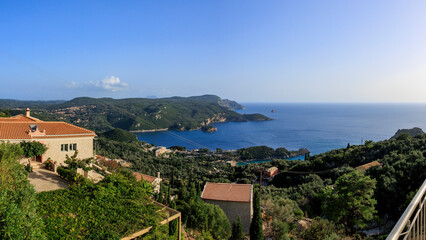 Fototapeta na wymiar View in the evening under a blue sky over the bay and the sea at Paleokastrtitsa on the island of Corfu