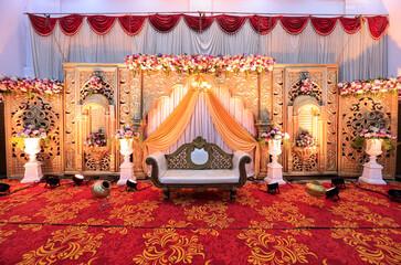 A view of a royal wedding stage setup with a luxury chair for the marriage event - obrazy, fototapety, plakaty