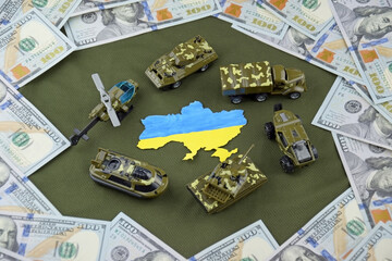 A battle tank with the Ukraine flag on a background of US dollar banknotes.