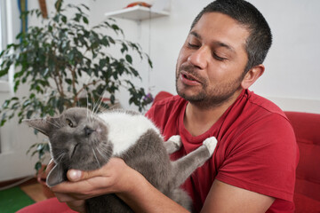 Feline Fun: Man Relaxing on Sofa with Gray Cat
