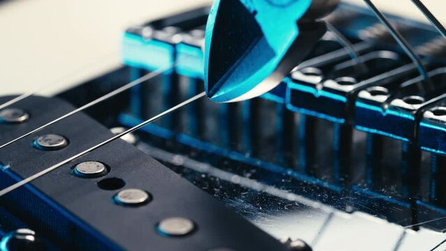 Musician cuts guitar string pliers. Replacing strings electric music instrument
