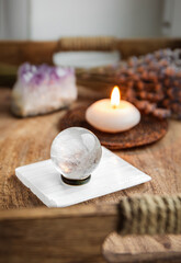 Fototapeta na wymiar Gemstone sphere or crystal balls known as crystallum orbis and orbuculum which is the beacon of peace and harmony in home environment. Natural clear quartz ball on stand on wood tray in home.