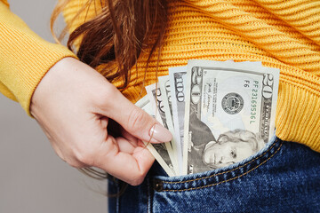Pocket money background. Dollar bills in front pocket. Woman in blue jeans. Sexy girl in trousers. Woman in jeans. American style fashion. Hand reaching for money. Long hair businesswoman.
