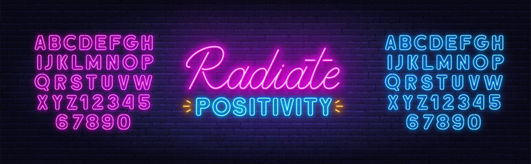 Radiate Positivity neon lettering on brick wall background.