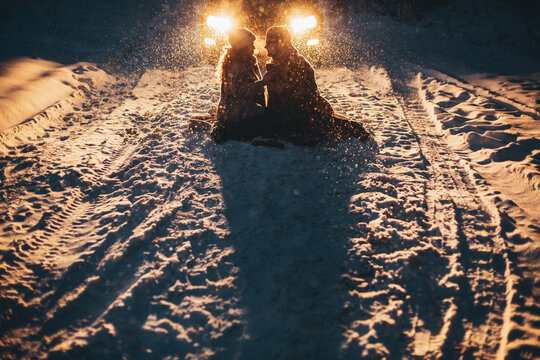 Young Couple In Love Holding Hands Outdoor In Winter At Night With Lights On Background. Christmas Time. Happy Valentine`s Day.