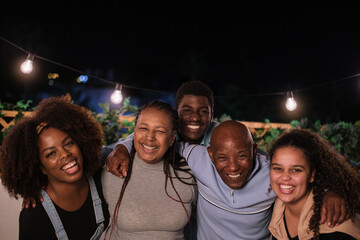 Fototapeta premium Portrait of family smiling and enjoying an evening outdoors on their terrace. Concept: love, family, fun